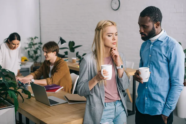 Compañeros Negocios Multiculturales Con Tazas Café Teniendo Discusión Dos Compañeros — Foto de Stock