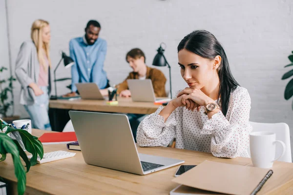 Młoda Kobieta Oglądanie Ekranie Laptopa Kolegów Pracujących Nowoczesnym Biurze — Zdjęcie stockowe