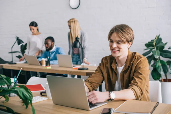 Sonriente Hombre Negocios Con Portátil Colegas Que Trabajan Detrás Oficina — Foto de Stock