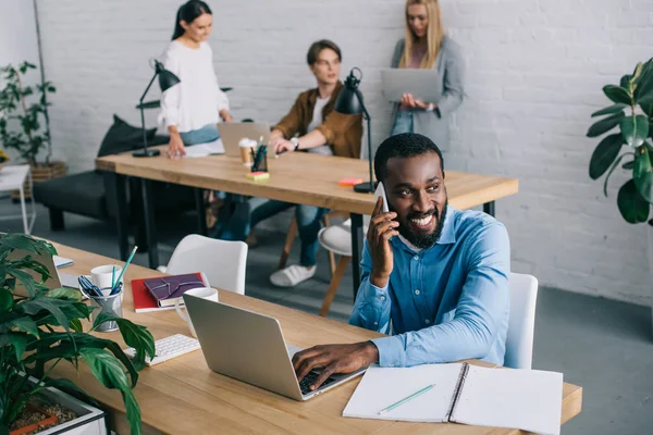 Empresário Afro Americano Conversando Smartphones Colegas Trabalhando Para Trás — Fotografia de Stock