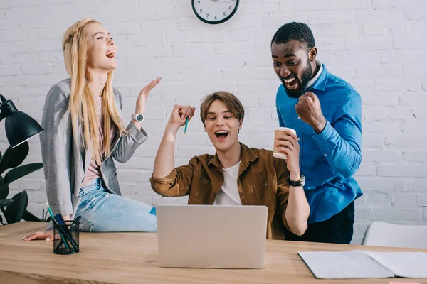 Upphetsad Mångkulturella Företagare Firar Vid Bord Med Laptop Moderna Kontor — Stockfoto