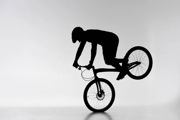 Silhouette Cycliste Essai Exécutant Support Roue Avant Sur Blanc — Photo