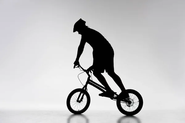 试骑自行车的剪影在白色的脚踏车平衡 — 图库照片