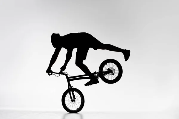 Sylwetka Próbny Biker Wykonywania Przednie Koło Równoważenia Stunt Rowerze Białym — Zdjęcie stockowe