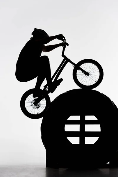 Silhouette Von Trial Biker Springt Auf Traktorrad Auf Weiß — kostenloses Stockfoto