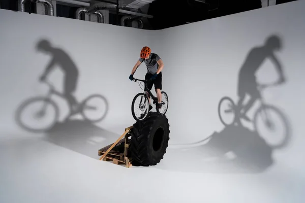 Young Trial Biker Helmet Balancing Tractor Wheel — Stock Photo, Image