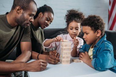 Kamuflaj giysileri ahşap bloklar oyunu oynarken onların çocukları ile anne