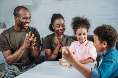 Afrikalı-Amerikalı kadın ve erkek askerler ahşap bloklar oyun oynayan çocukları ile birlikte