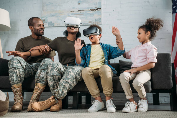 Happy family with children and parents in camouflage clothes using vr glasses