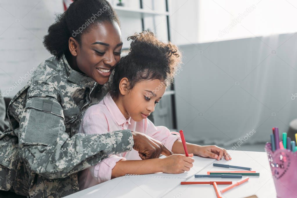 Mother soldier and african american child drawing together