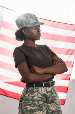 Önümüzde bayrak kamuflaj giysili genç Afrikalı-Amerikalı kadın asker
