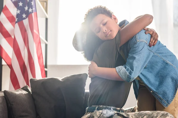 Woman Camouflage Clothes Her Son Embracing Sofa — Stock Photo, Image