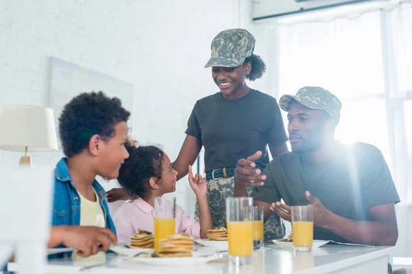 女と男の台所のテーブルで子どもと一緒に軍服で  — 無料ストックフォト