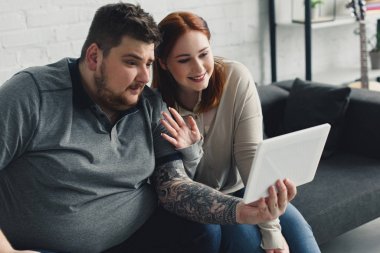 evde tablet görüntülü arama sırasında kız arkadaşı sallanan el gülümseyen