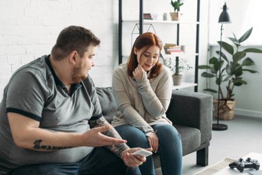 Smartphone'da evde üzgün kız arkadaşına işaret eden erkek