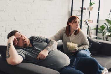 uyku kanepe ve patlamış mısır tutarak ve yolu görünümlü kız erkek evde