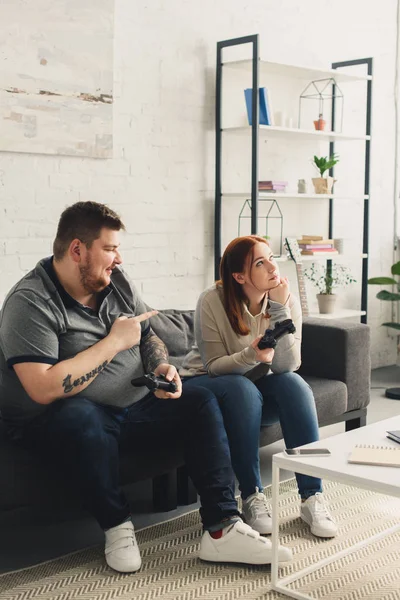 Boyfriend Pointing Girlfriend While Playing Video Game Home — Free Stock Photo