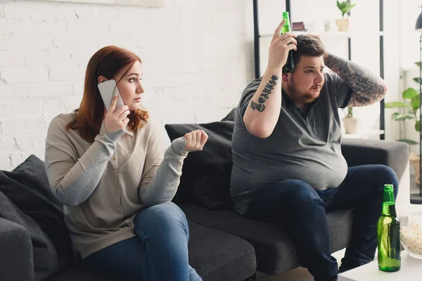 Namorada Falando Por Smartphone Olhando Para Namorado Assistindo Com Cerveja — Fotografia de Stock Grátis