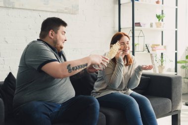 kilolu erkek smartphone tarafından evde konuşmak kız patlamış mısır atma