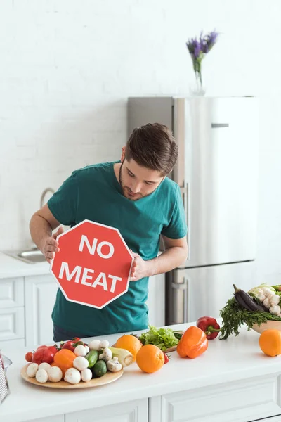 英俊的素食男人看在厨房没有肉标志 — 免费的图库照片