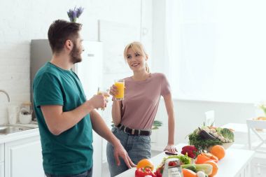 couple of vegans talking at kitchen and holding juice clipart