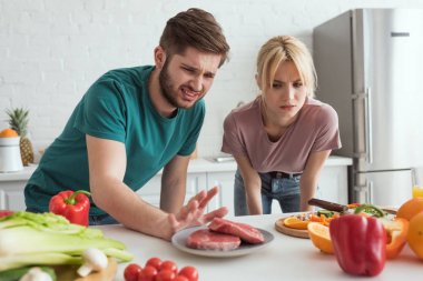 tiksinti vegan çift çiğ et evde mutfak plaka üzerinde