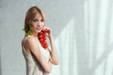 taze roka, vegan yaşam tarzı kavramı kiraz domates el ve küpe genç kadınla yapılan