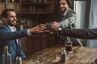 kırpılan kadeh viski bardakları tokuşturup ve birlikte parti mutlu genç iş adamları