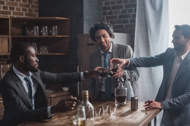 viski bardakları tokuşturup ve birlikte parti çok ırklı erkek arkadaşlar gülümseyen