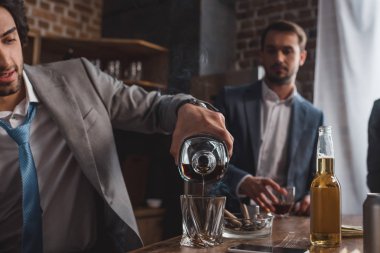 takım elbise dökme viski arkasında, arkadaş ise insanın kırpılmış atış