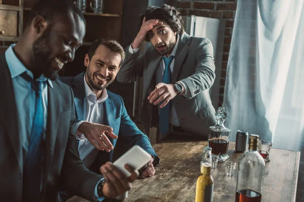 Homme Émotionnel Regardant Rire Amis Utilisant Son Smartphone Pendant Fête — Photo