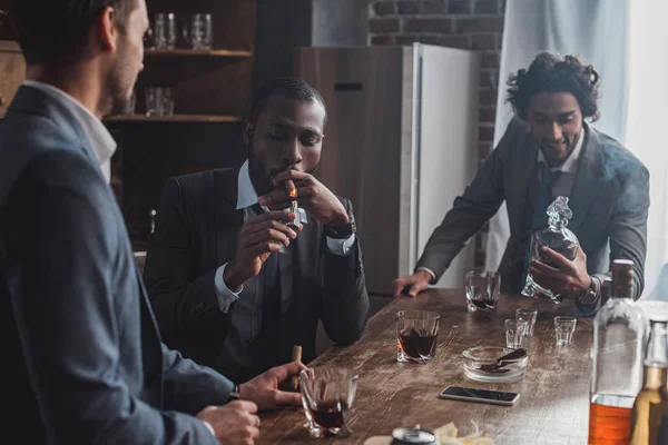 Tres Hombres Multiétnicos Trajes Fumando Cigarros Bebiendo Alcohol Juntos — Foto de stock gratis