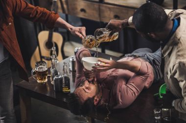 arkadaşlar bira huni ve masanın üzerinde yatan ise içerken adam dökme kırpılmış atış