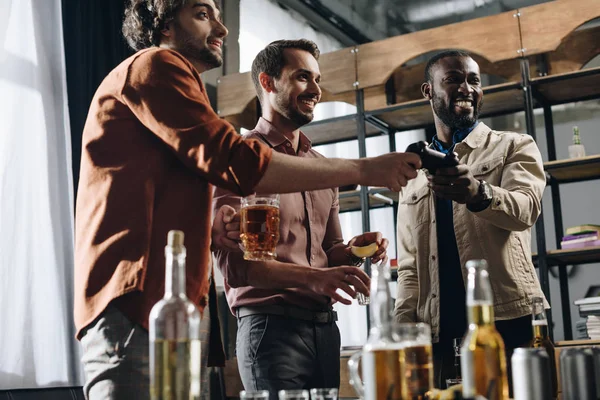Low Angle View Smiling Multiethnic Men Playing Joystick Drinking Alcohol — Free Stock Photo