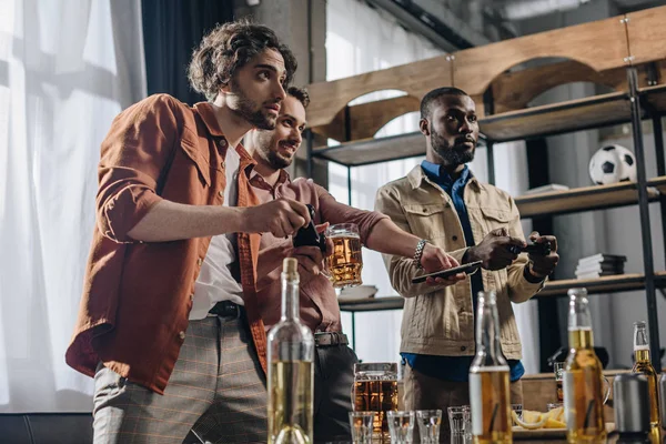 Low Angle View Multiethnic Men Playing Joysticks Drinking Beer Together — Free Stock Photo