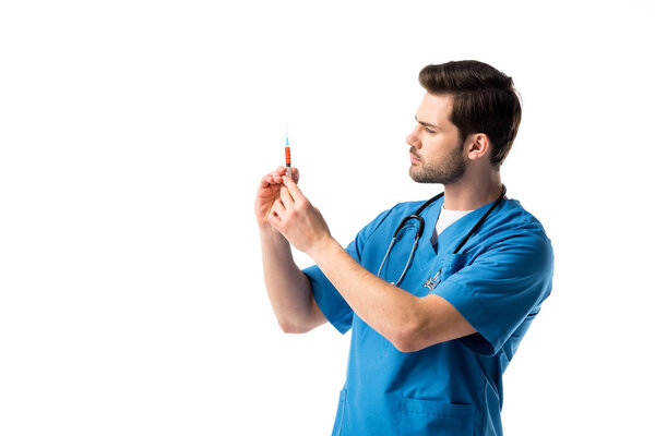 Male nurse wearing blue uniform with stethoscope and filling syringe isolated on white