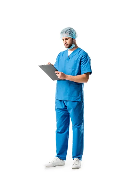 在白色的剪贴板上穿着蓝色制服和书写的体贴的医务工作者 — 图库照片