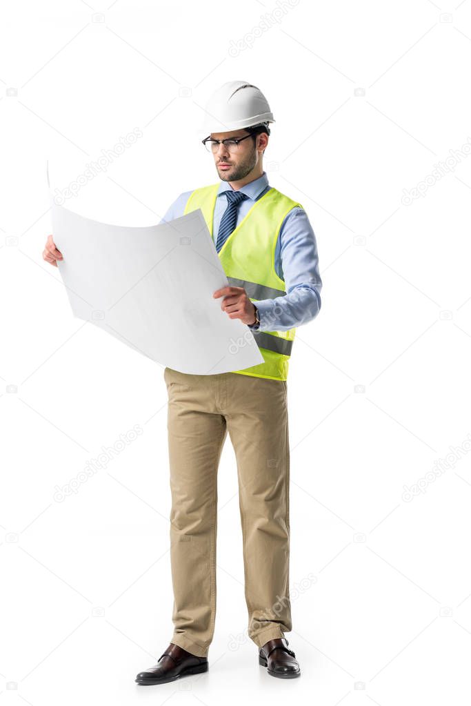 Thoughtful builder in reflective vest and helmet looking at blueprint isolated on white