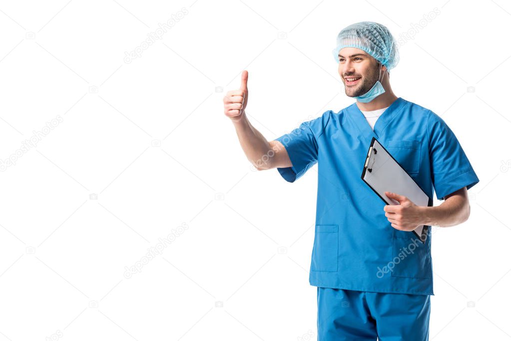 Male nurse with clipboard wearing blue uniform and showing thumb up isolated on white