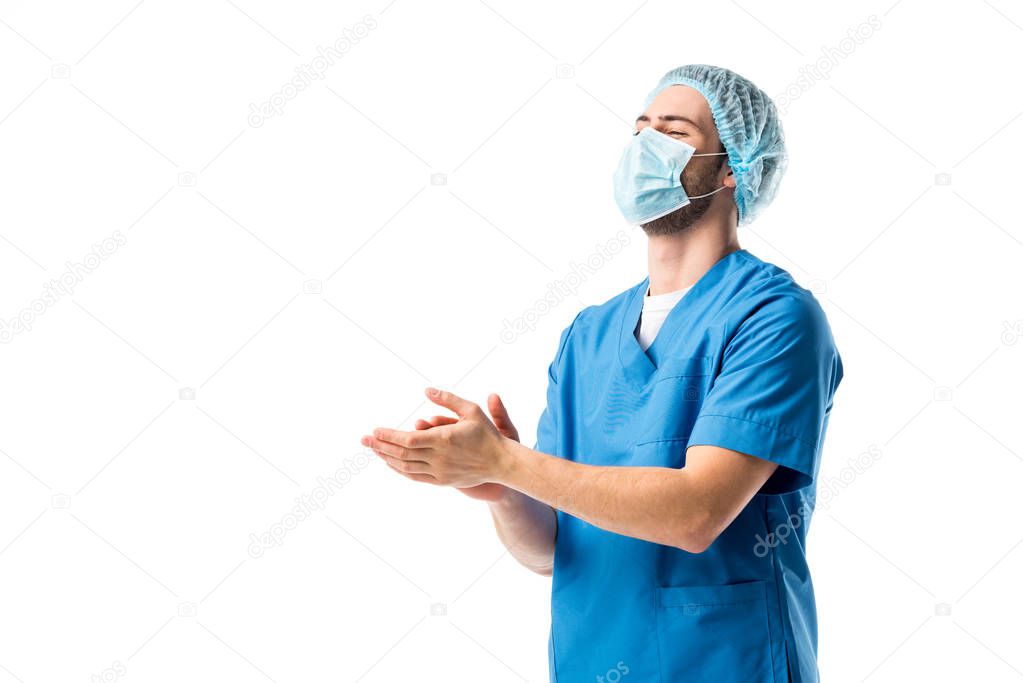 Male nurse wearing blue uniform and applauding isolated on white