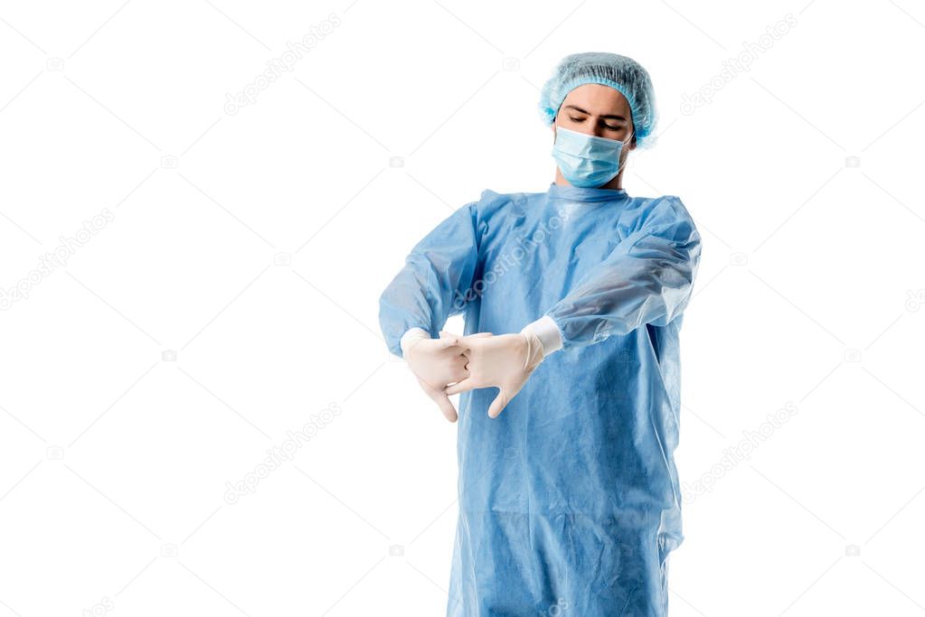 Surgeon wearing blue uniform stretching his hands isolated on white
