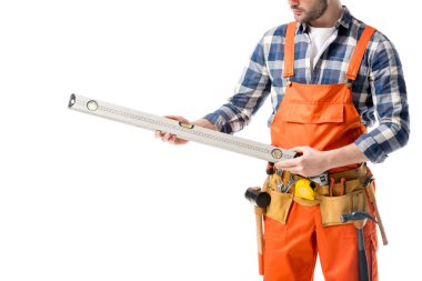 Close-up view of spirit level in hands of workman in orange overall isolated on white clipart