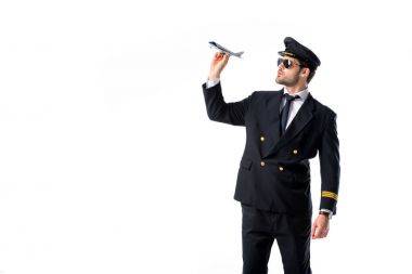 Genç sakallı pilot üniforması ve güneş gözlüğü ile üzerine beyaz izole oyuncak uçak