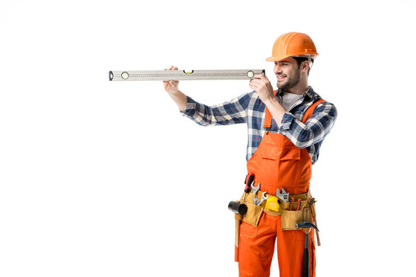 Young repairman in orange overall checking spirit level isolated on white