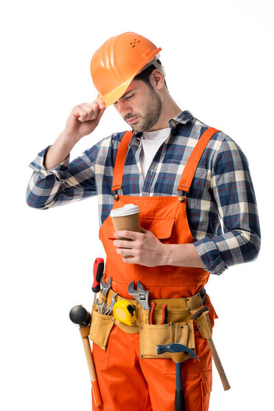 Repairman in orange overall and helmet holding coffee cup isolated on white