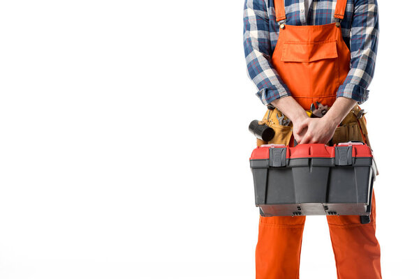 Cropped view of workman in orange overall holding tool box isolated on white