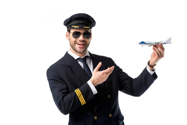 肖像微笑胡子飞行员在制服指向玩具飞机在手上隔绝白色 — 图库照片
