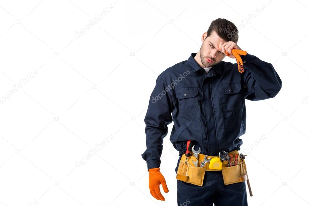 portrait of tired plumber in uniform and protective gloves looking away isolated on white