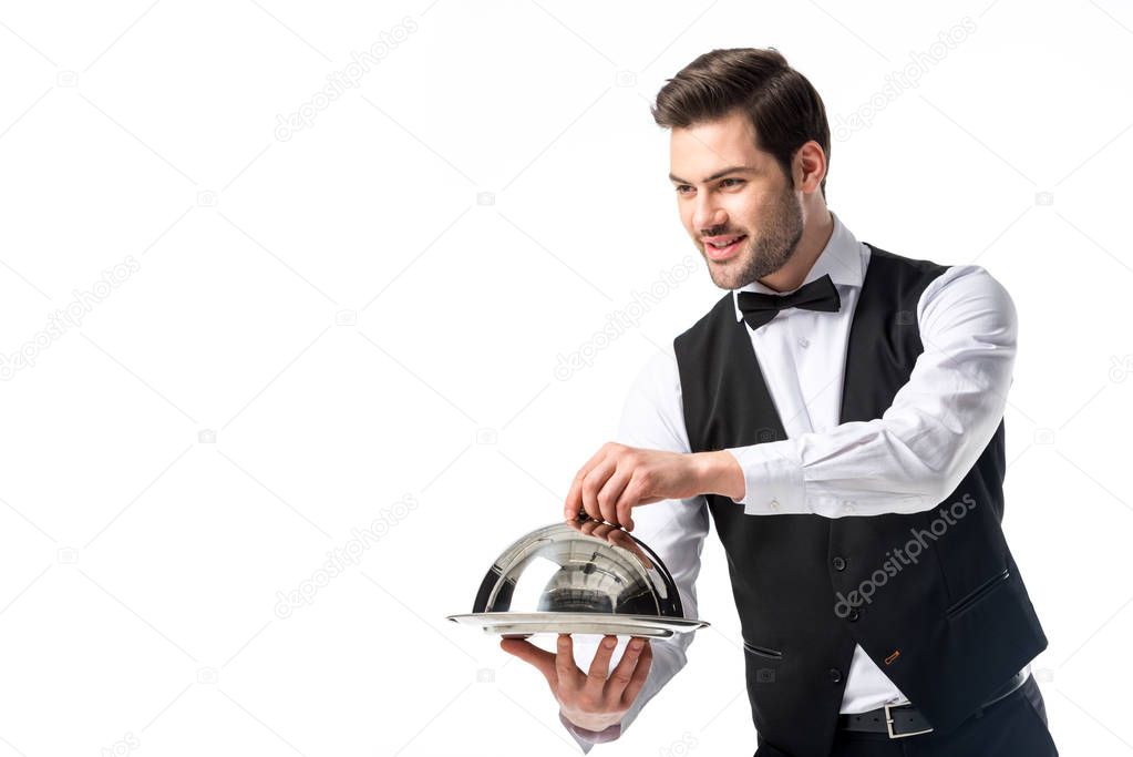 portrait of handsome bearded waiter in suit vest with serving tray isolated on white