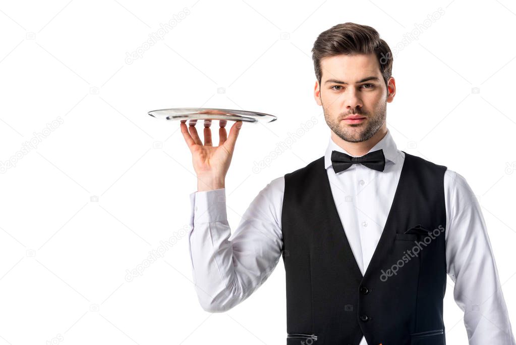 portrait of handsome waiter in suit vest with empty serving tray isolated on white